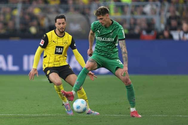 Ramy Bensebaini Borussia Dortmund and Tomas Cvancara Borussia Moenchengladbach in a duel during the Bundesliga 1 match between Borussia Dortmund and Borussia Moenchengladbach, SIGNAL IDUNA PARK on April 20, 2025 in Dortmund, Germany, Germany Photo by Oliver Kaelke DeFodi Images Ramy Bensebaini Borussia Dortmund and Tomas Cvancara Borussia Moenchengladbach battle for the ball during the Bundesliga match between Borussia Dortmund and Borussia Mönchengladbach at Signal Iduna Park on April 20, 2025 in Dortmund, Germany Photo by Oliver Kaelke DeFodi Images DFL regulations prohibit any use of photographs as image sequences and or quasi video Photo by Oliver Kaelke DeFodi Images