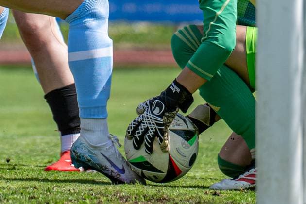27 04 2025, Football, 2 Womens Bundesliga, 2024 2025, Matchday 23, FC Bayern München U 20 SG 99 Andernach Goalkeeper holds the ball with her goalkeeper gloves while the striker kicks the ball with her foot Aschheim Sportpark Aschheim Bavaria Germany