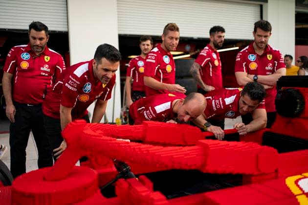 Scuderia Ferrari mechanics look at a full-sized Lego car during the Formula One Miami Grand Prix at the Miami International Autodrome in Miami Gardens, Florida on Thursday, May 1, 2025.  MIA2025050135 GREGxNASH