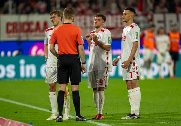 Timo Huebers 1 FC Koeln, 4 , Luca Waldschmidt 1 FC Koeln, 9 and Dejan Ljubicic 1 FC Koeln, 7 stand with Felix Wagner DFB referee, Gloett while Nicolas Winter DFB referee, Hagenbach at the VAR video assist video evidence, Videobeweis, Video Assist, Video Beweis, TV Beweis steht 1 FC Köln SSV Jahn Regensburg, 03 05 2025 Fußball, 2 Bundesliga, RheinEnergieStadion Köln DFL regulations prohibit any use of photographs as image sequences and or quasi video Copyright: HMBxMedia xMarcoxBader