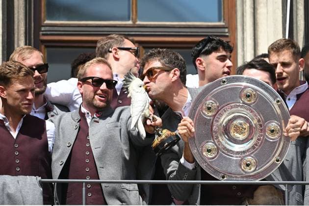 Thomas MUELLER MÜLLER,Bayern Muenchen celebrates on the Rathausbalkon,kisses the porcelain cockatoo and holds the bowl,Meisterschale Fussball Bundesliga der Frauen und der Maenner Doppelfeier FC Bayern Muenchen,Meisterfeier auf dem Rathausbalkon auf dem Marienplatz in Muenchen am 18 05 2025 Fussball 1 Bundesliga Saison 2024 2025, 34 Spieltag,