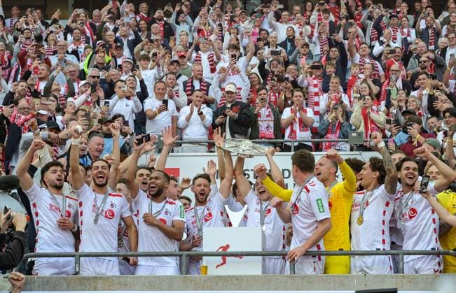 18 05 2025, xjpx, Fussball 2 Bundesliga, 1 FC Koeln 1 FC Kaiserslautern v l Champions of the 2 Bundesliga 1 FC Koeln The team celebrates with the trophy presented by Mark Uth Koeln on the left and captain Timo Hübers Koeln on the right DFL DFB REGULATIONS PROHIBIT ANY USE OF PHOTOGRAPHS as IMAGE SEQUENCES and or QUASI VIDEO Koeln