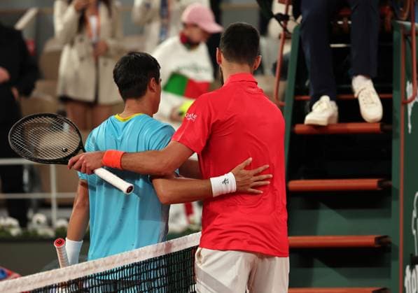 Novak Djokovic of Serbia (R) hugs Mackenzie McDonald of the US at the end of their first-round match at the French Tennis Open in Roland Garros in Paris, France, on Tuesday, May 27, 2025. Djokovic won 6-3, 6-3, 6-3.  PAR20250527315 MAYAxVIDON-WHITE