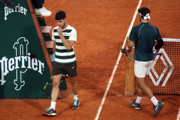 Lorenzo Musetti of Italy and Carlos Alcaraz of Spain (L) trade sides during their semi-final match at the French Tennis Open in Roland Garros in Paris, France, on Friday, June 6, 2025. Alcaraz advanced to the final after Musetti withdrew due to an injury in the fourth set.  PAR20250606111 MAYAxVIDON-WHITE