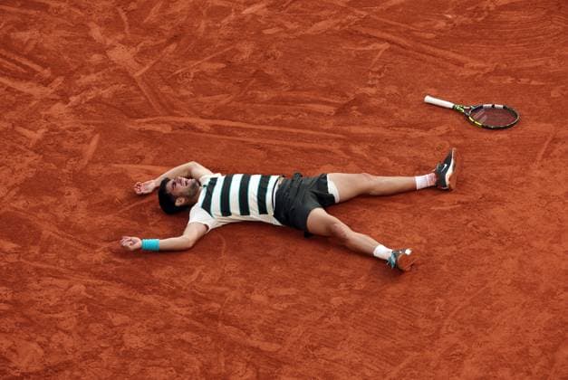 Second-seed Carlos Alcaraz of Spain collapses onto the court after winning against top-seeded Jannik Sinner of Italy in the Men s Finals of the French Open Tennis Championship at Roland-Garros in Paris on Sunday, June 8, 2025. Alcaraz won the open in nearly five and a half hours, the longest men s final ever in Paris history.  PAR20250608105 MAYAxVIDON-WHITE