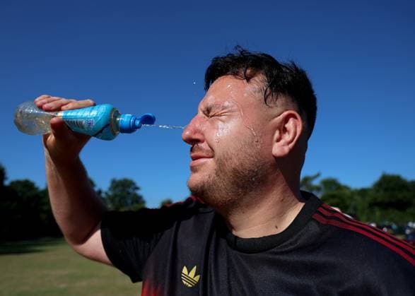 30th June 2025; All England Lawn Tennis and Croquet Club, London, England; Wimbledon Tennis Tournament, Day 1; A Spectator splashing water on his face to keep cool while queueing in the morning during a heatwave  ActionPlus12807196 JohnxPatrickxFletcher