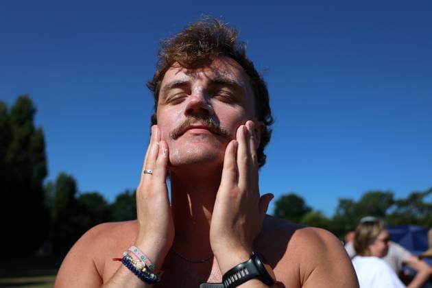 30th June 2025; All England Lawn Tennis and Croquet Club, London, England; Wimbledon Tennis Tournament, Day 1; A Spectator applies sun lotion to his face while queueing in the morning during a heatwave  ActionPlus12807197 JohnxPatrickxFletcher