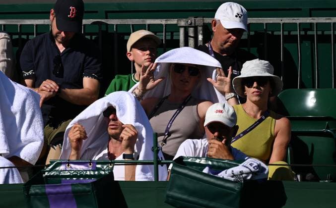 (250701) -- LONDON, July 1, 2025 -- Spectators protect their faces from the sun with hats and towels on the opening day of the Wimbledon Championships in London, Britain, June 30, 2025. Tennis fans faced the hottest start to Wimbledon on record on Monday as temperature soared to 32 degrees Celsius. ) BRITAIN-LONDON-TENNIS-WIMBLEDON-OPENING DAY-WEATHER LixYing 
