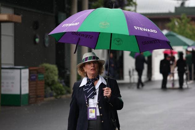 2nd July 2025; All England Lawn Tennis and Croquet Club, London, England; Wimbledon Tennis Tournament, Day 3; Wimbledon Steward under a Wimbledon Umbrella as heavy rain pours down on day three of the Wimbledon Championships  ActionPlus12807828 JohnxPatrickxFletcher