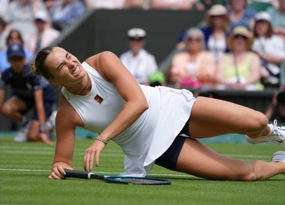 Tennis - 2025 Wimbledon Championships - Women™s Singles - Round Two - Aryna Sabalenka v Marie Bouzkova All England Lawn Tennis & Croquet Club - Wednesday 2nd July 2025 Aryna Sabalenka feels the pain as she slips on the grass 