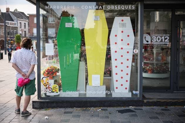 TOUR DE FRANCE 2025 PHOTOPQR VOIX DU NORD PIERRE ROUANET ; 02 07 2025 ; VALENCIENNES, 02 07 2025. L affichage dans le centre ville de Valenciennes avant le depart de la troisieme etape du Tour de France cycliste 2025, Valenciennes-Dunkerque. Derriere la vitrine des pompes funebres PFG, place d’Armes, trois cercueils aux couleurs des maillots du Tour de France. PHOTO PIERRE ROUANET LA VOIX DU NORD- French cycling race Tour de France 2024 takes place in july 2025 funeral shop with Tour de France coffins HAUTS DE FRANCE France  Copyright: xPHOTOPQR VOIXxDUxNORD MAXPPPxPIERRExROUANETx 20250702VDN2061 20250702VDN2061
