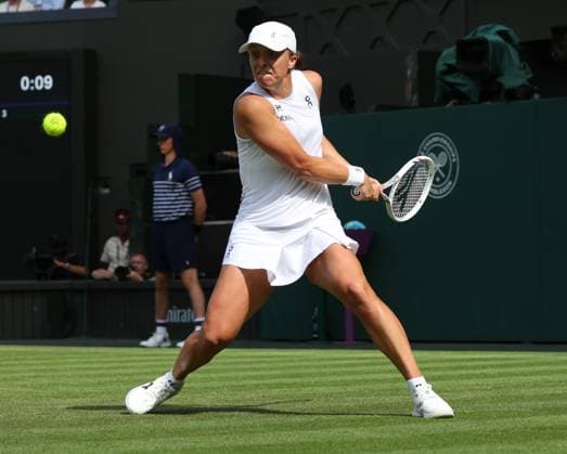 Poland s Iga Swiatek plays a backhand in her second round match against American Caty Mcnally on day four of the 2025 Wimbledon Championships in London on Thursday, June 03, 2025.  LON2025070327 HUGOxPHILPOTT