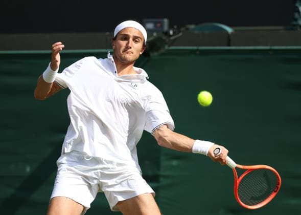 Italian Mattia Bellucci plays a forehand in his third round match against Great Britain s Cameron Norrie on day five of the 2025 Wimbledon Championships in London on Friday, July 04, 2025.  LON2025070452 HUGOxPHILPOTT
