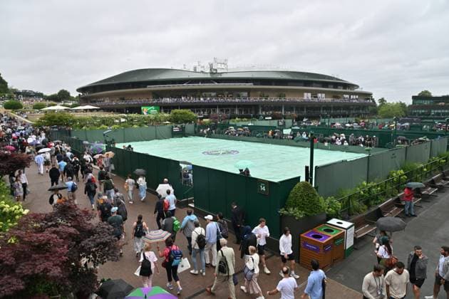 Wimbledon Tennis Championships - Day 6 LONDON, ENGLAND - July 05: Spectators shield themselves from light rain stops play during day six of The Championships Wimbledon 2025 at All England Lawn Tennis and Croquet Club on July 05, 2025 in London, England. Ray Tang Anadolu London United Kingdom. Editorial use only. Please get in touch for any other usage.  Copyright: x2025xAnadoluxRayxTangx
