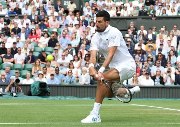 Serbian Novak Djokovic plays a backhand in his fourth round match against Australia s Alex De Minaur on day eight of the 2025 Wimbledon Championships in London on Monday, July 07, 2025.  LON2025070701 HUGOxPHILPOTT