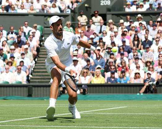 Serbian Novak Djokovic plays a forehand in his fourth round match against Australia s Alex De Minaur on day eight of the 2025 Wimbledon Championships in London on Monday, July 07, 2025.  LON2025070708 HUGOxPHILPOTT