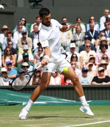 Serbian Novak Djokovic plays a forehand in his fourth round match against Australia s Alex De Minaur on day eight of the 2025 Wimbledon Championships in London on Monday, July 07, 2025.  LON2025070721 HUGOxPHILPOTT