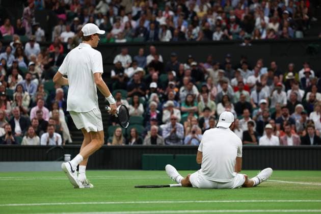 7th July 2025; All England Lawn Tennis and Croquet Club, London, England; Wimbledon Tennis Tournament, Day 8; Grigor Dimitrov (BUL) sits on the court after damaging his pectoral muscle from serving to Jannik Sinner (ITA) as Jannik Sinner (ITA) comes over to help him  ActionPlus12811283 JohnxPatrickxFletcher