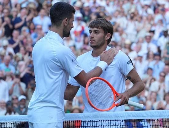 Tennis - 2025 Wimbledon Championships - Men™s singles- Quarter Final - Flavio Cobolli v Novak Djokovic All England Lawn Tennis & Croquet Club - Wednesday 9th July 2025 Novak Djokovic consoles Cobolli at the net after the match 