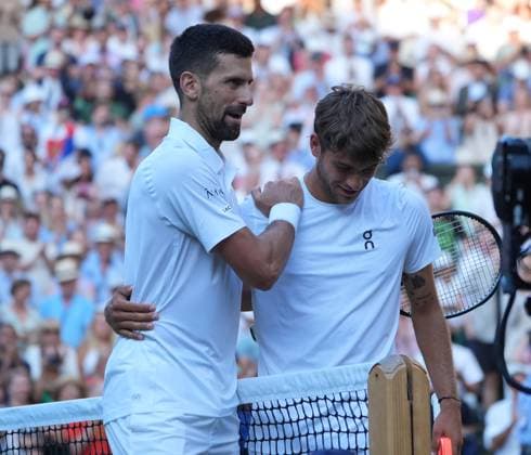 Tennis - 2025 Wimbledon Championships - Men™s singles- Quarter Final - Flavio Cobolli v Novak Djokovic All England Lawn Tennis & Croquet Club - Wednesday 9th July 2025 Novak Djokovic consoles Cobolli at the net after the match 