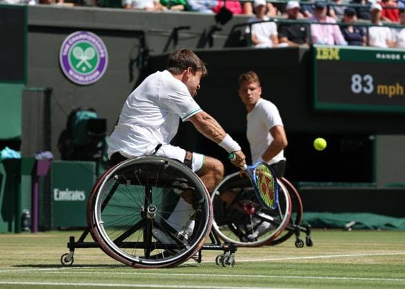 12th July 2025; All England Lawn Tennis and Croquet Club, London, England; Wimbledon Tennis Tournament, Day 13; Martin De La Puente (ESP) with a backhand shot to Gordon Reid (GBR) with doubles partner Ruben Spaargaren (NED) watching on in their men s wheelchair doubles final  ActionPlus12812513 JohnxPatrickxFletcher