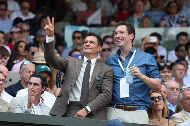 13th July 2025; All England Lawn Tennis and Croquet Club, London, England; Wimbledon Tennis Tournament, Day 14; Hollywood actor Orlando Bloom with a guest gesturing to a friend Niall in the stands watching Centre Court Gentlemen& x2019;s Single Final between Jannik Sinner (ITA) vs Carlos Alcaraz (ESP)  ActionPlus12813422 JohnxPatrickxFletcher