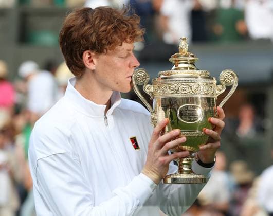 Italian Jannik Sinner holds the Men s Wimbledon singles trophy after defeating Spain s Carlos Alcaraz on day fourteen of the 2025 Wimbledon Championships in London on Sunday, July 13, 2025. Sinner won 4-6,6-4,6-4,6-4.  LON2025071372 HUGOxPHILPOTT