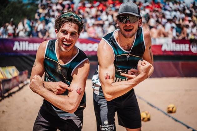 Beach volleyball men Allianz German Beach Tour 2025 Tourstop Munich 13 07 2025 f l Lui Wüst and Paul Henning cheer after winning the semi-final and point to a tattoo with the portrait of the injured Daniel Kirchner Munich Central University Sports Munich Bavaria Germany
