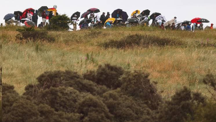 The 153rd Open Championship, Royal Portrush Golf Club, Co. Antrim 15 7 2025 Fans shelter from the rain Fans shelter from the rain 15 7 2025  Copyright: x INPHO BenxBradyx BB3_5178