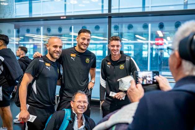 SOCCER - UEFA ECL, Decic vs Rapid SCHWECHAT,AUSTRIA,23.JUL.25 - SOCCER - UEFA Europa Conference League, qualification, FK Decic Tuzi vs SK Rapid Wien, preview, departure Rapid. Image shows Lukas Grgic, Ercan Kara and Bendeguz Bolla (Rapid) with a fan taking pictures at the Airport.  GEPAxpictures xKevinxHackner