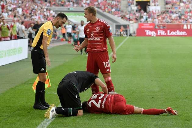 Matthias Zimmermann Duesseldorf 25 injured on the ground Boris Tomiak Hannover 3 bent over him 09 08 2025 Soccer Fortuna Duesseldorf vs Hannover 96 , Merkur Spiel Arena, Duesseldorf, DFB DFL REGULATIONS PROHIBIT ANY USE OF PHOTOGRAPHS AS IMAGE SEQUENCES AND OR QUASI VIDEO Copyright: xpepphotox xHorstxMauelshagenx pep00321, pep_2025089_hm_103789