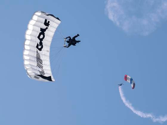 BOLINGBROOK, IL - AUGUST 09: A parachuter flys over the course to start day two of LIV Golf Chicago on Saturday, August 09, 2025 at Bolingbrook Golf Club in Bolingbrook, IL. (Photo by Joseph Weiser Icon Sportswire) GOLF: AUG 09 LIV Golf Chicago EDITORIAL USE ONLY Icon250809007