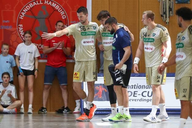 10 08 2025, xgox, Handball Heide Cup match for 3rd place TSV Hannover Burgdorf Kadetten Schaffhausen emspor, v l Maxim Orlov Hannover, 11 has to leave the field after a duel, duel, fight, tackle with support, injured, injury Schneverdingen