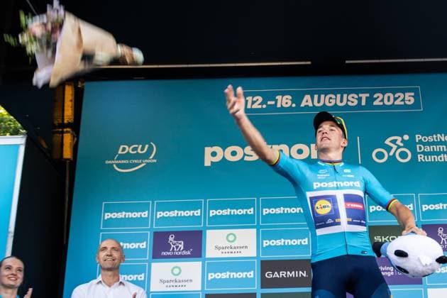 August 13, 2025, Gladsaxe, Denmark: Mads Pedersen of Denmark and Lidl - Trek seen wearing the blue leader s jersey throws flowers from the podium after the 2 stage of PostNord Danmark Rundt 2025. The second stage of the PostNord Danmark Rundt 2025 cycling race starts in Rodovre and finishes in Gladsaxe. Gladsaxe Denmark - ZUMAs197 20250813_aaa_s197_089 Copyright: xKristianxTuxenxLadegaardxBergx