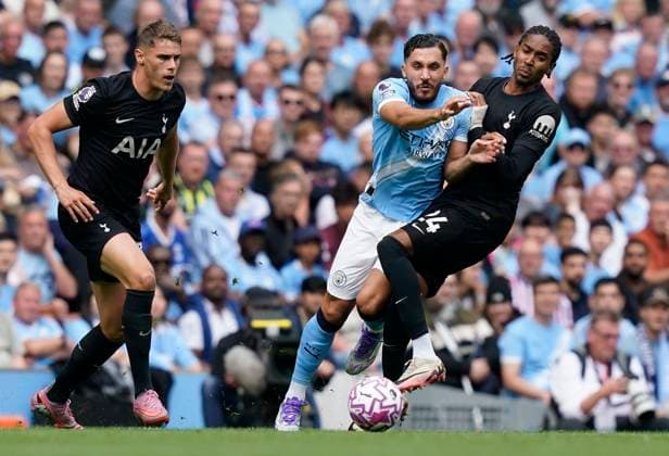 Manchester, England, 23rd August 2025. Rayan Cherki of Manchester City (C) is challenged by Djed Spence of Tottenham during the Manchester City vs Tottenham Hotspur Premier League match at the Etihad Stadium, Manchester. Picture credit should read: Andrew Yates Sportimage EDITORIAL USE ONLY. No use with unauthorised audio, video, data, fixture lists, club league logos or live services. Online in-match use limited to 120 images, no video emulation. No use in betting, games or single club league player publications. SPI_001_AY_MAN_CITY_SPURS SPI-4081-0001