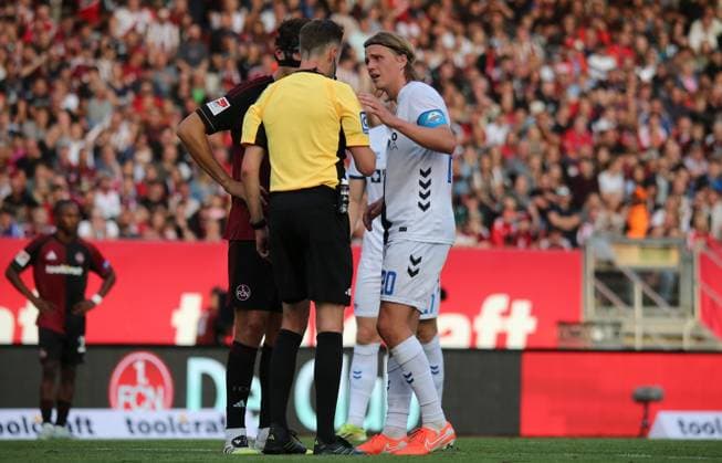 29 08 2025, xmohx, Fußball 2 Bundesliga, 1 FC Nuernberg SC Paderborn 07 v l Tim Janisch Nürnberg fouls Luis Engelns Paderborn , whereupon referee Michael Bacher shows him the red card, Janisch then shows disappointment and the red card is rescinded by the VAR Referee Bacher tells captain felix Götzpe paderborn that the sending off will be rescinded and Tim Janisch Nuremberg may return to the pitch DFL DFB REGULATIONS PROHIBIT ANY USE OF PHOTOGRAPHS as IMAGE SEQUENCES and or QUASI VIDEO Nuernberg