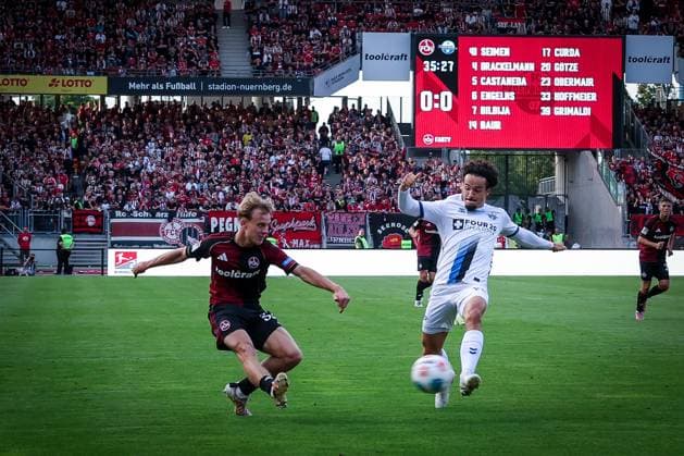 left to right Tim Janisch 32 1FC Nuernberg with a cross that Mika Baur 14 SC Paderborn 07 cannot prevent, 1 FC Nuernberg vs SC Paderborn 07, DFL, 2 Bundesliga, Saison 2025 2026, Max Morlock Stadion, 4 Spieltag, Hinrunde, 29 08 2025 DFB regulations prohibit any use of photographs as image sequences and or quasi video Nuernberg Bayern Germany Copyright: xkolbert-press MartinxAgüerax