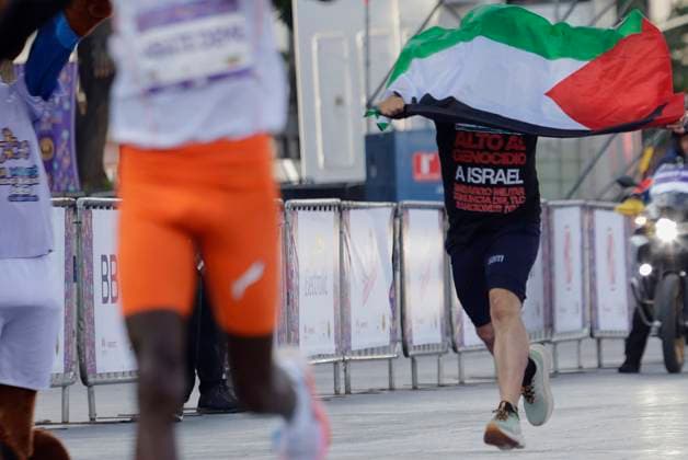 XLII Telcel Marathon 2025 Mexico City Elite runner Tadu Adate Deme (orange shorts) is about to cross the finish line and take first place in the men s category of the XLII Telcel Marathon in Mexico City, Mexico, on August 31, 2025, when a person bypasses the security fence to also cross the finish line carrying a flag in support of Palestine and the Global Sumud Flotilla, which departs this Sunday from Barcelona to Gaza to provide humanitarian aid. Mexico City Mexico City Mexico  Copyright: xGerardoxVieyrax originalFilename:vieyra-notitle250831_npOH1.jpg