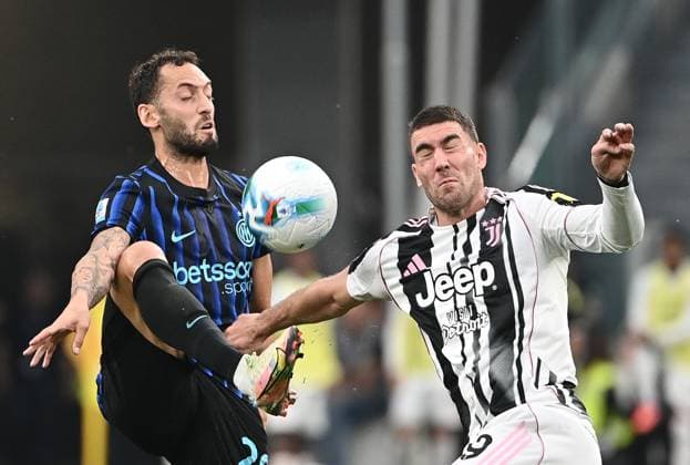 Juventus v Inter Milan - Serie A TURIN, ITALY - SEPTEMBER 13: Turkish forward Hakan Calhanoglu (L) in action with Serbian Dusan Vlahovic (R) during the Italian Serie A football match Juventus vs Inter at Allianz stadium in Turin on September 13, 2025. Isabella Bonotto Anadolu Turin Italy. Editorial use only. Please get in touch for any other usage.  Copyright: x2025xAnadoluxIsabellaxBonottox