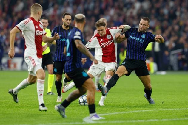 AMSTERDAM , 17-09-2025 , JohanCruyff Arena , season 2025 2026 , UEFA Champions League football , League phase Matchday 1 , match between Ajax and Inter Milan , picture shows Inter player Hakan Calhanoglu, Ajax player Mika Godts, Inter player Stefan de Vrij Ajax - Inter  x31066646x Copyright: