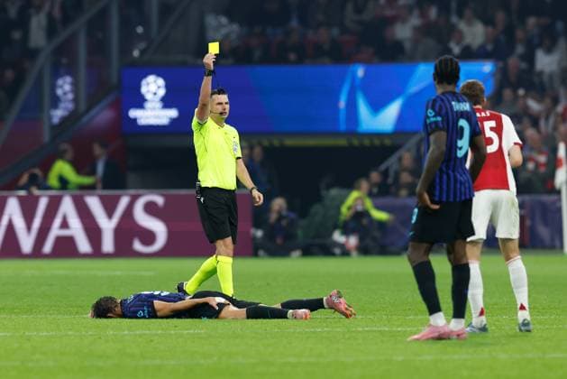 AMSTERDAM , 17-09-2025 , JohanCruyff Arena , season 2025 2026 , UEFA Champions League football , League phase Matchday 1 , match between Ajax and Inter Milan , picture shows referee Michael Oliver yellow card Ajax player Youri Baas Ajax - Inter  x31067468x Copyright: