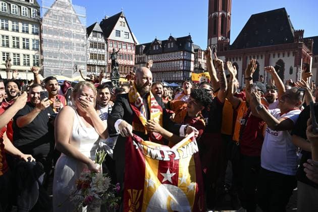 Ahead of UEFA Champions League: Eintracht Frankfurt v Galatasaray FRANKFURT, GERMANY - SEPTEMBER 18: Fans of Galatasaray cheer to celebrate a newlywed couple, and the bride and groom join in the chants at the Romerberg Square ahead of UEFA Champions League football match between Eintracht Frankfurt and Galatasaray in Frankfurt, Germany on September 18, 2025. Halil Sagirkaya Anadolu Frankfurt Germany. Editorial use only. Please get in touch for any other usage.  Copyright: x2025xAnadoluxHalilxSagirkayax