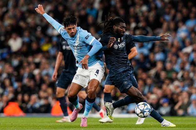 Manchester, England, 18th September 2025. Tijjani Reijnders of Manchester City and AndrÃ -Frank Zambo Anguissa of SSC Napoli battle for the ball during the Manchester City vs Napoli UEFA Champions League match at the Etihad Stadium, Manchester. Picture credit should read: Andrew Yates Sportimage EDITORIAL USE ONLY. No use with unauthorised audio, video, data, fixture lists, club league logos or live services. Online in-match use limited to 120 images, no video emulation. No use in betting, games or single club league player publications. SPI_039_AY_MCI_NAP SPI-4144-0072