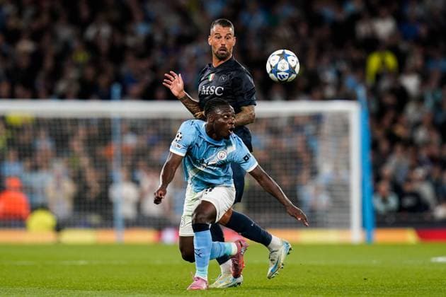 Manchester, England, 18th September 2025. Jeremy Doku of Manchester City looks to control the ball under pressure from Leonardo Spinazzola of SSC Napoli during the Manchester City vs Napoli UEFA Champions League match at the Etihad Stadium, Manchester. Picture credit should read: Andrew Yates Sportimage EDITORIAL USE ONLY. No use with unauthorised audio, video, data, fixture lists, club league logos or live services. Online in-match use limited to 120 images, no video emulation. No use in betting, games or single club league player publications. SPI_041_AY_MCI_NAP SPI-4144-0074