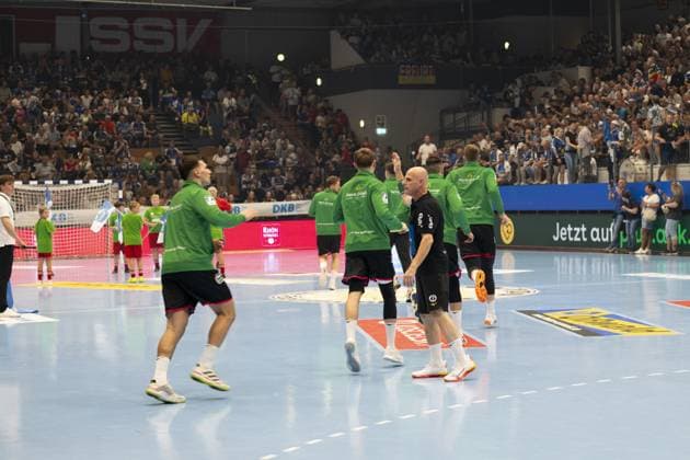 Several HSG Wetzlar players in green warm-up jerseys run onto the pitch in the Werner Assmann Halle in Eisenach DAIKIN Handball ThSV Eisenach vs HSG Wetzlar 20 09 2025 Copyright: xJoshuaxHildebrandtx