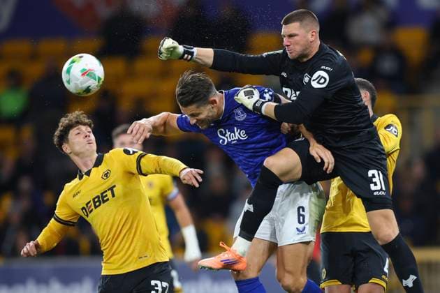 Wolverhampton, England, 23rd September 2025. Sam Johnstone of Wolverhampton Wanderers punches the ball clear ahead of James Tarkowski of Everton during the Wolverhampton Wanderers vs Everton Carabao Cup match at Molineux, Wolverhampton. Picture credit should read: James Baylis Sportimage EDITORIAL USE ONLY. No use with unauthorised audio, video, data, fixture lists, club league logos or live services. Online in-match use limited to 120 images, no video emulation. No use in betting, games or single club league player publications. SPI_129_JB_WOL_EVE SPI-4157-0127