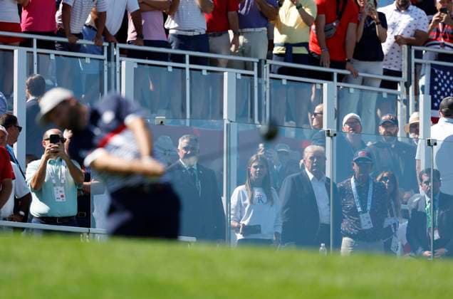 President Donald Trump watches Scottie Scheffler of Team United States tee off on the first hole during four-ball competition against Team Europe on day one of the 45th Ryder Cup at The Bethpage Black Course in Farmingdale, New York on Friday, September 26, 2025.  RYD20250926814 JOHNxANGELILLO