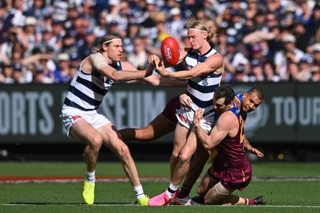 2025 AFL GRAND FINAL, Oliver Dempsey of Geelong (centre) handballs the footy while being tackled by Darcy Gardiner of the Lions during the AFL Grand Final between the Geelong Cats and the Brisbane Lions at the Melbourne Cricket Ground in Melbourne, Saturday, September 27, 2025. ( NO ARCHIVING, EDITORIAL USE ONLY MELBOURNE VICTORIA AUSTRALIA  Copyright: xJAMESxROSSx 20250927119235613109
