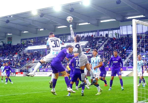 Goalkeeper Martin Männel Aue fists in front of Maximilian Wolfram Munich, left , in between Pascal Fallmann Aue Football 3 Liga 2025 26 FC Erzgebirge Aue TSV 1860 Munich on 27 9 2025 Erzgebirge Aue 1860 Munich