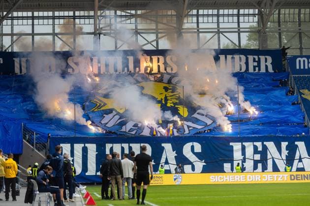 Jena , 270925, Soccer Regionalliga , FC Carl Zeiss Jena vs Chemnitzer FC in the picture Fans Ultras Jena Horda provoke interruption of the game by blocking two escape gates with banners and fans in the block
